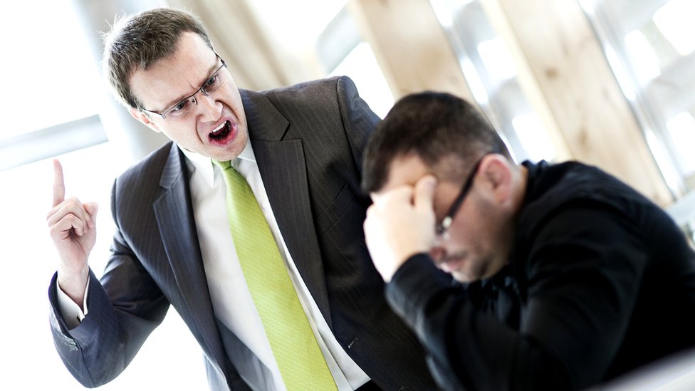 La intimidación y el acosos son rasgos de los psicópatas. Hombre de negocios de pie regañando a otro.
