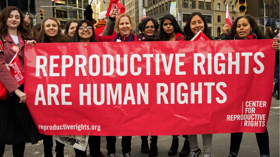 Un grupo de mujeres sujeta una pancarta que lee: "Los derechos reproductivos son derechos humanos"