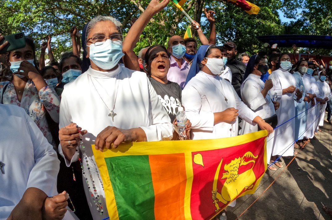 Sri Lankan catholic nuns shield protesters during a demonstration near the president's office in Colombo on 24 April 2022