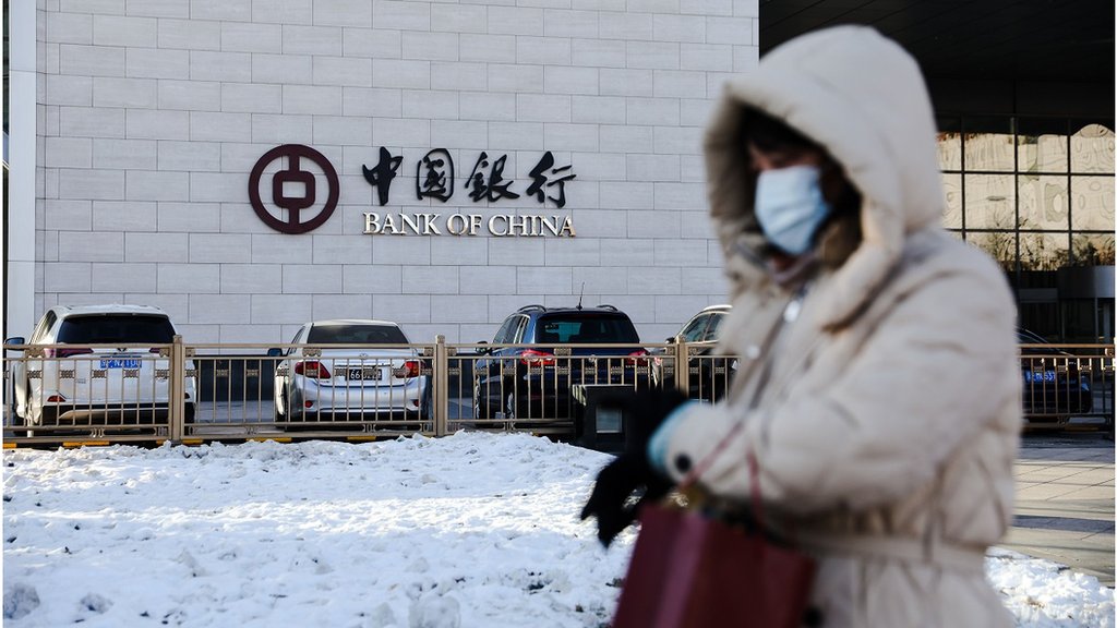 一名戴著口罩的女士走過北京中央商務區（2023年12月20日）。