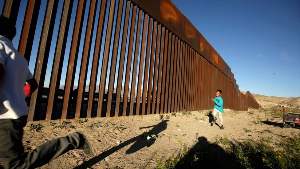 Дети бегают вдоль пограничного забора между Мексикой и США во время межрелигиозной службы у пограничной стены президента США Дональда Трампа в Сьюдад-Хуаресе, Мексика, 26 февраля 2019 г.