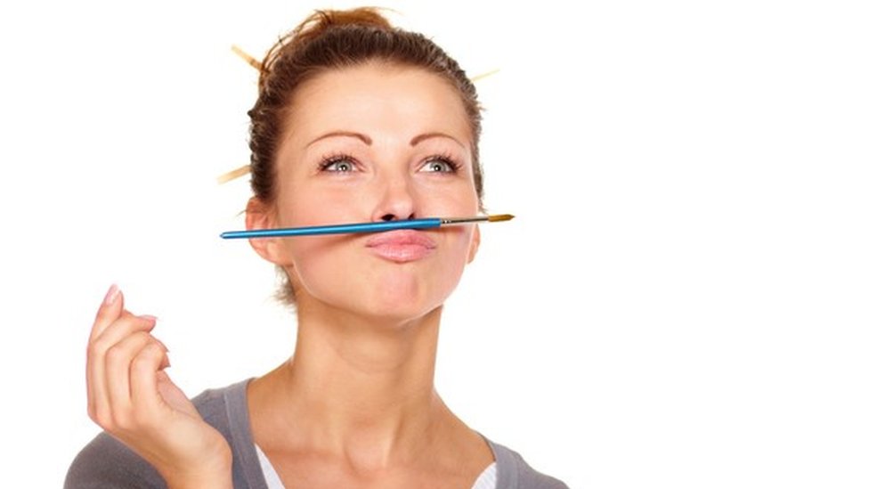 Los momentos de esparcimiento mental deberían ser parte formal de la rutina en los negocios. Una mujer que mira al horizonte, con un lápiz entre el labio superior y la nariz