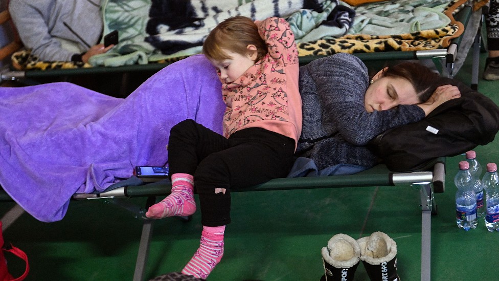 Una mujer duerne con su hija pequeña en un centro para refugiados en Hungría