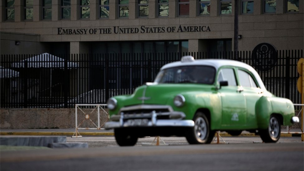 Зеленая машина проезжает мимо посольства США в Гаване