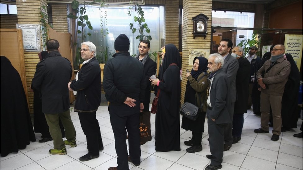 عدد من الناخبين والناخبات يصطفون انتظارا لفتح باب أحد مراكز التصويت في العاصمة طهران