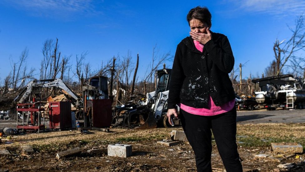 Una mujer llora frente a un cúmulo de escombros luego de los tornados que afectaron a cinco estados de Estados Unidos.