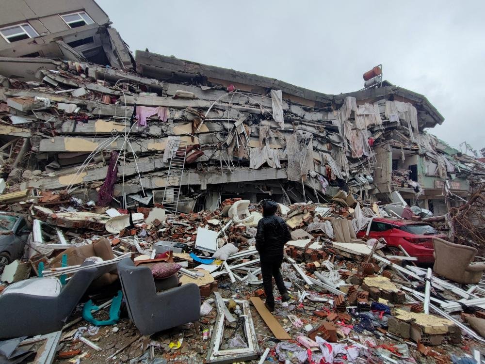 A man stands in front of collapsed buildings following an earthquake in Kahramanmaras, Turkey, 6 February 2023