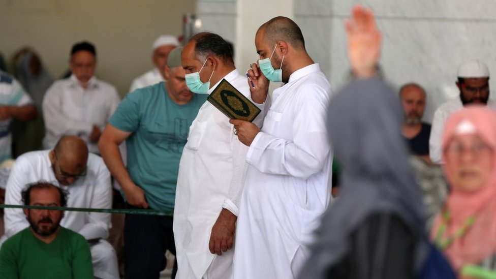 Umat Islam menggunakan masker saat Sholat Jumat di depan Masjid Agung Makkah.