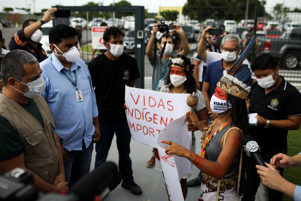 Вандерлеция разговаривает с Робсоном Сантосом да Силва, когда она принимает участие в акции протеста