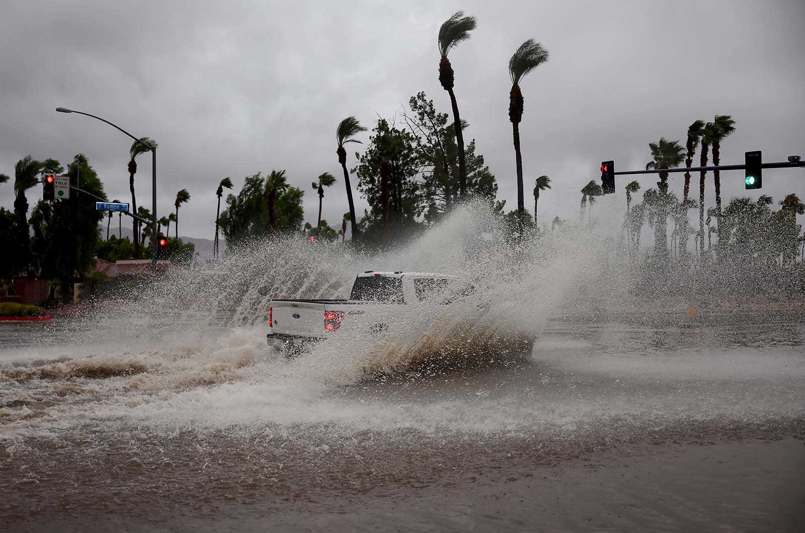 A vehicle drives through a flooded street from Tropical Storm Hilary in Cathedral City, California - 20 August, 2023 