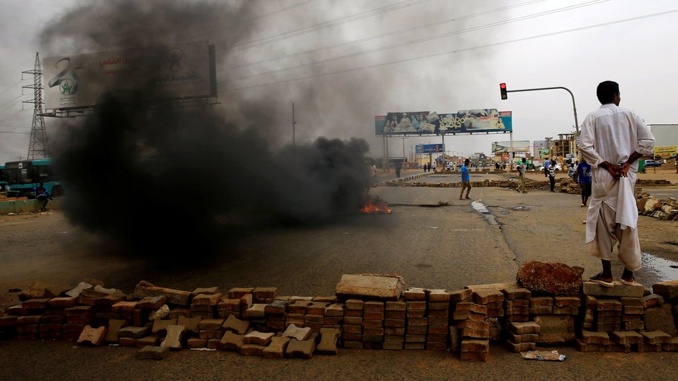 Суданский протестующий стоит возле баррикады на улице, требуя, чтобы Временный военный совет страны передал власть гражданским лицам, в Хартуме, Судан, 4 июня 2019 года.