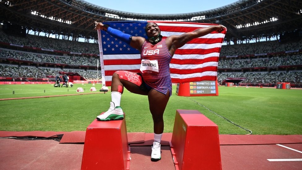 Raven Saunders posa com sua bandeira nacional enquanto comemora a conquista da medalha de prata