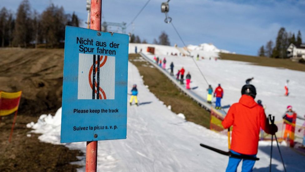 A sign informs ski tourists to keep on the track at a ski slope in Seefeld, Austria on January 2, 2023