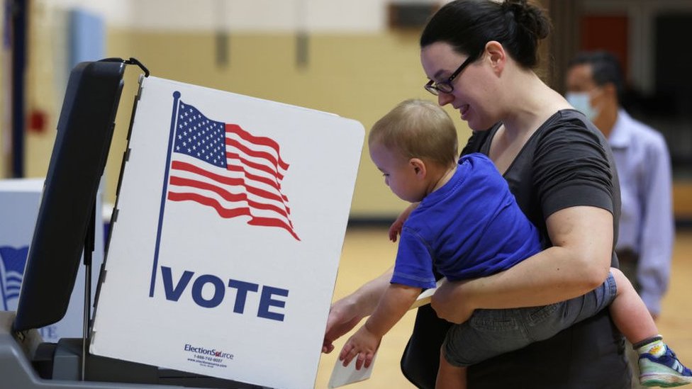 A voter casts her ballot with her child in Alexandria, Virginia