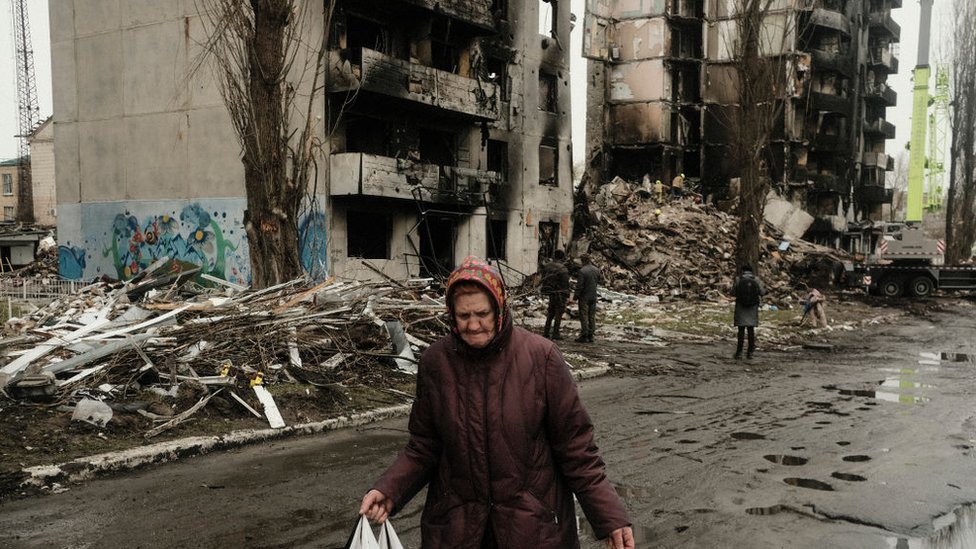 Una mujer pasa frente a edificios bombardeados en Borodyanka, Ucrania, 10 de abril 2022