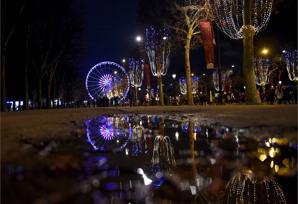 Luces y su reflejo en el agua adornan la Plaza de la Concordia en París.
