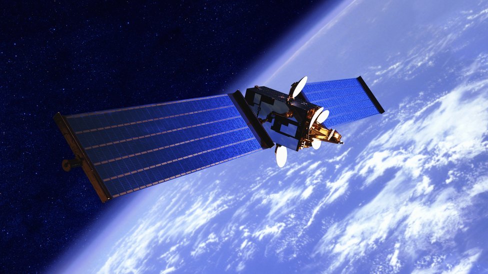 A stock image shows a communications satellite in orbit above the earth