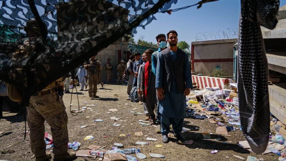 الجنود الأمريكيون يراقبون اللاجئين الأفغان الذين ينتظرون في طابور إجلاءهم في رحلة خروج من كابل