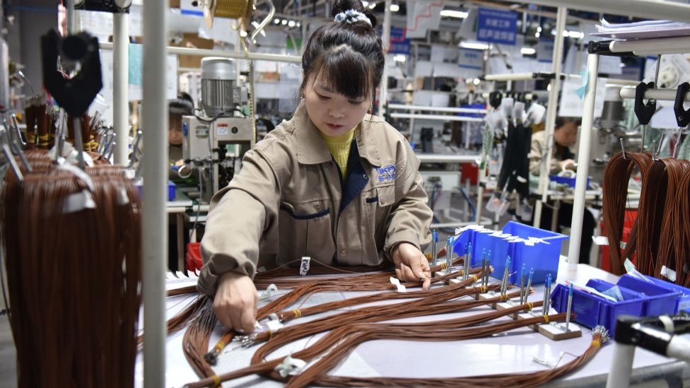 在中國安徽省阜陽市的一家汽車零部件工廠，一名女工正在組裝汽車線束。