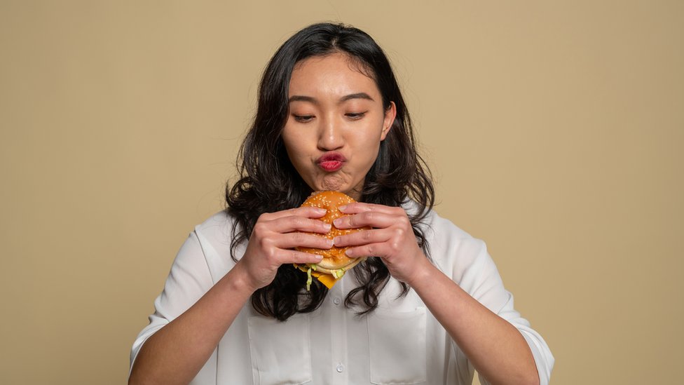 Mujer comiendo hamburguesa