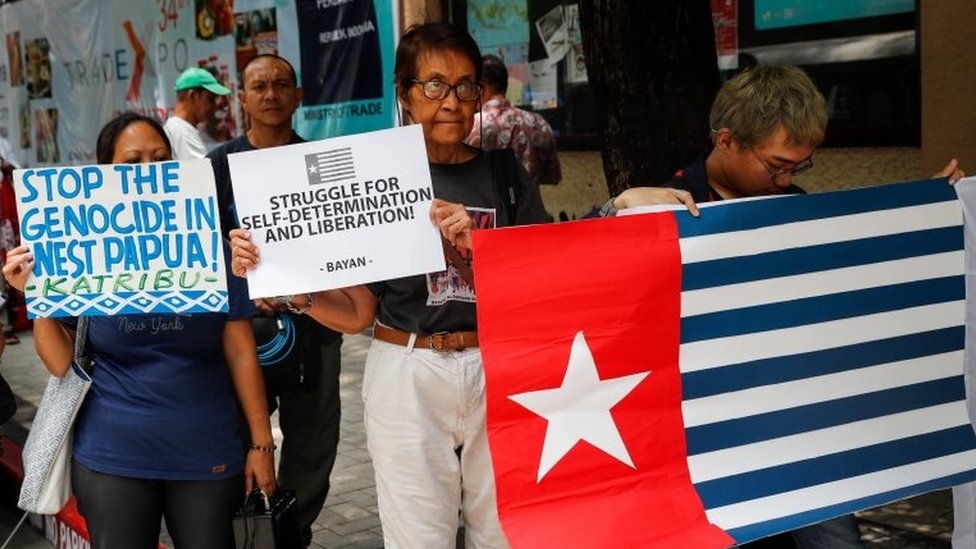 Активисты держат транспаранты и флаг Западного Папуа (флаг Morning Star) во время акции протеста перед посольством Индонезии в Маниле