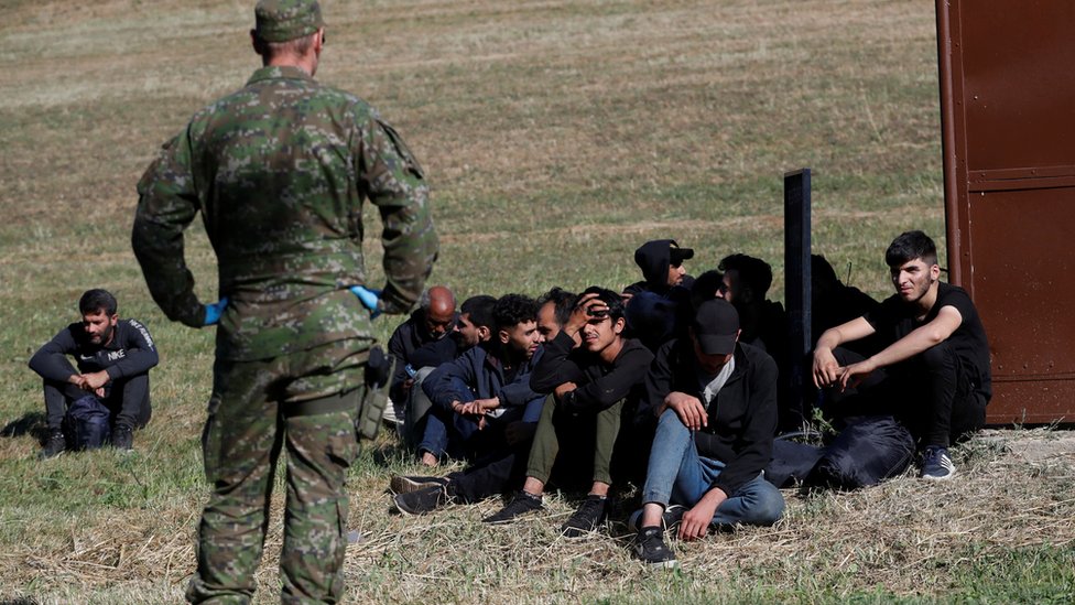 Migrants wait, as they are detained by Slovakian police, after illegally crossing the border close to the Slovakia-Hungary border in the village of Chl'aba, Slovakia, September 15, 2023
