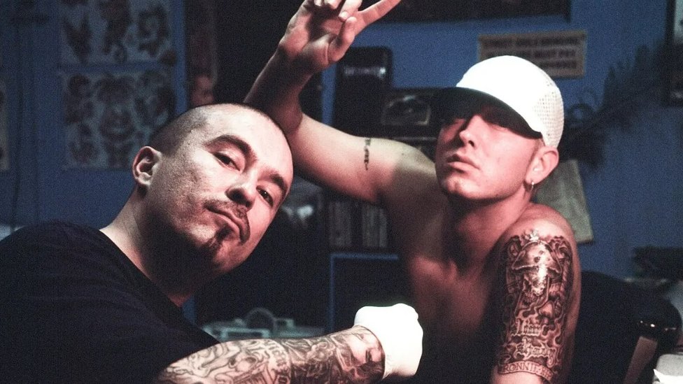 Hip-hop umetnici, poput Eminema (na slici ga tetovira Mister Kartun) uticali su na to da tetovaža postane masovno popularna
