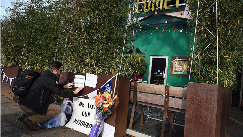Americano deixa mensagem de apoio em frente à pizzaria Comet Ping Pong em dezembro de 2016, um dia após homem armado ser preso no local