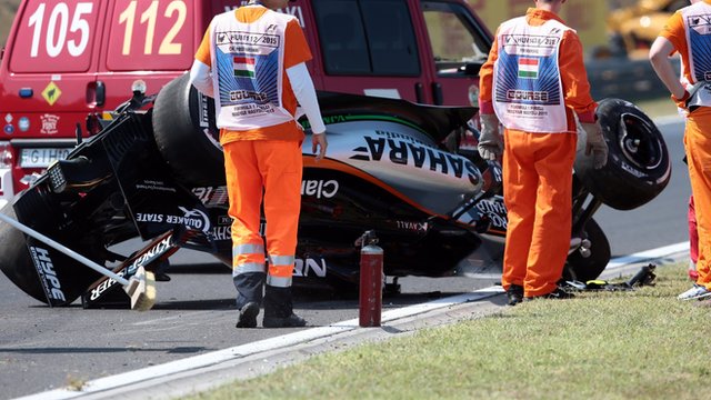 Marshals recover the upside-down Force India of Sergio Perez