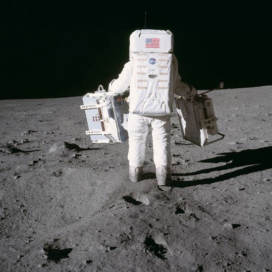 Aldrin carga experimentos antes de desplegarlos sobre la superficie de la Luna.