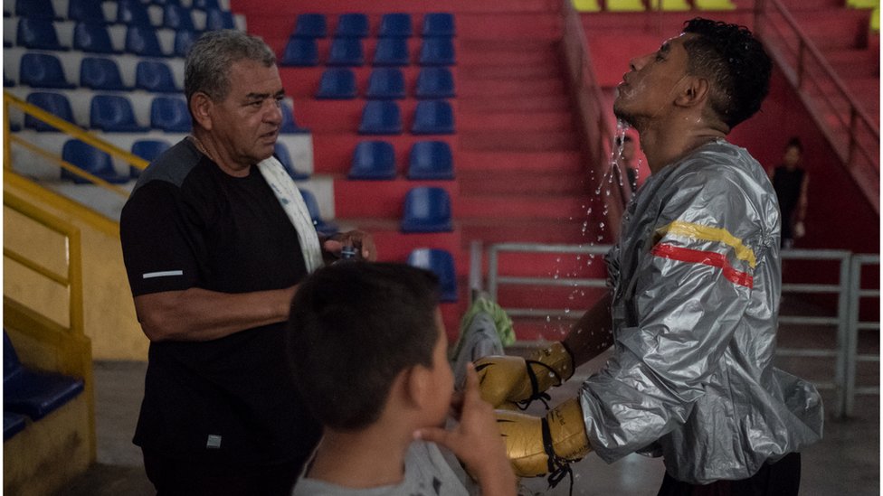 Боксер Рамиро Бланко поливает лицо водой во время тренировки