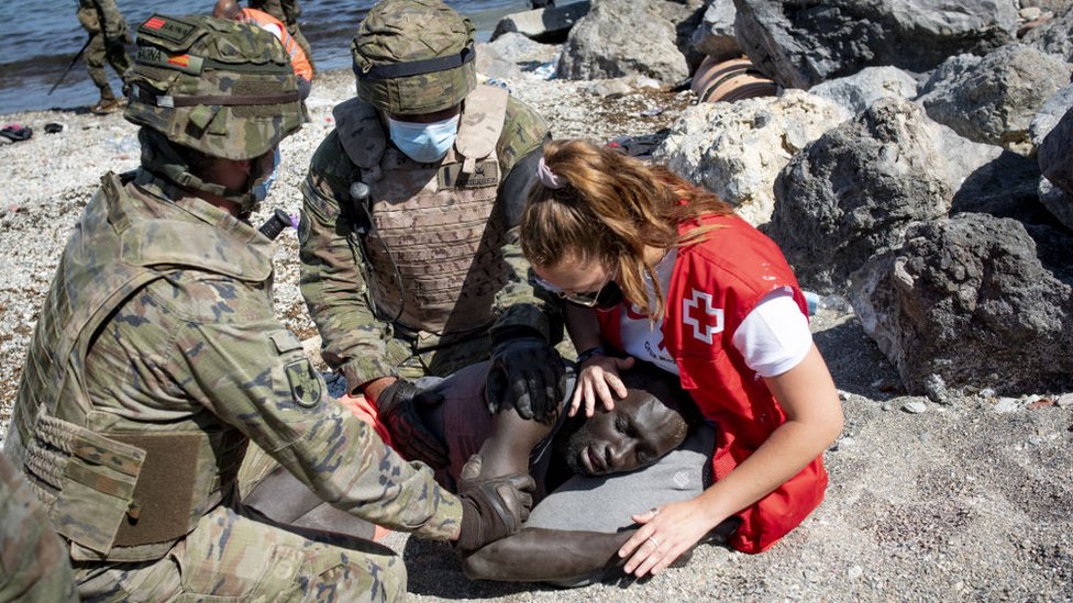 Una ayudante médica atendiendo a un migrante en la zona de Ceuta el 18 de mayo de 2021.