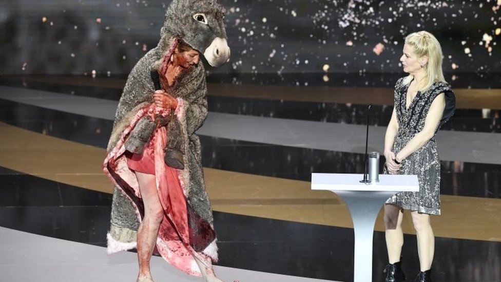 French actress Corinne Masiero (left) wears a donkey costume on top of a bloodied dress in Paris, France. Photo: 12 March 2021