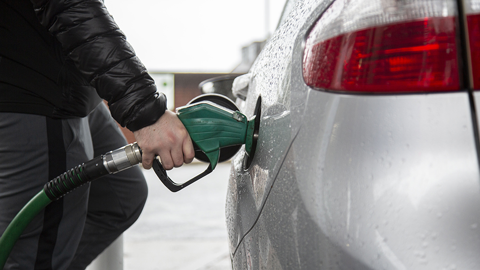 Man filling a car with petrol at UK station, February 2022