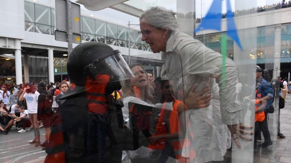 Una mujer se enfrenta a un policía Una mujer se enfrenta a un policía