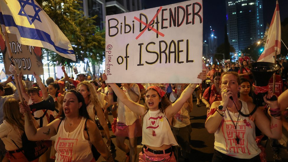 Demonstrantkinja sa plakatom "Bibi uništitelj Izraela"