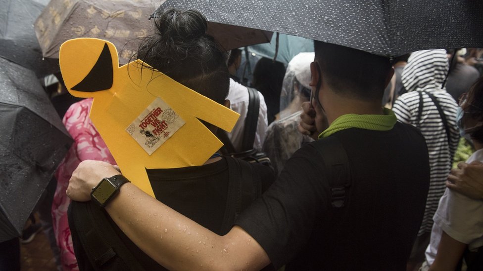 香港「反送中」示威「8·18流水式集會」群眾舉起黃色雨衣人像紙牌冒雨前行（8/8/2019）