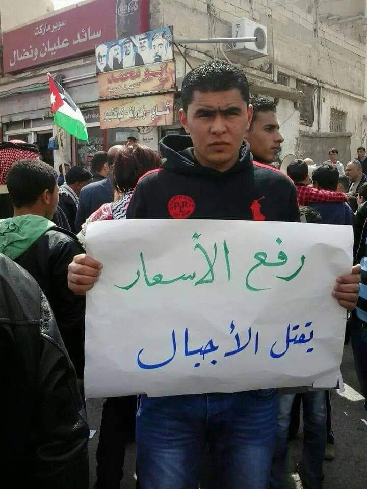 الناشط عبدالرحمن شديفات يرفع شعار ضد رفع الأسعار في الأردن