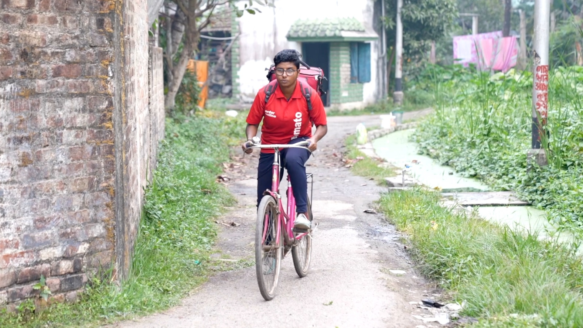 Poulami on her bicycle in her delivery uniform