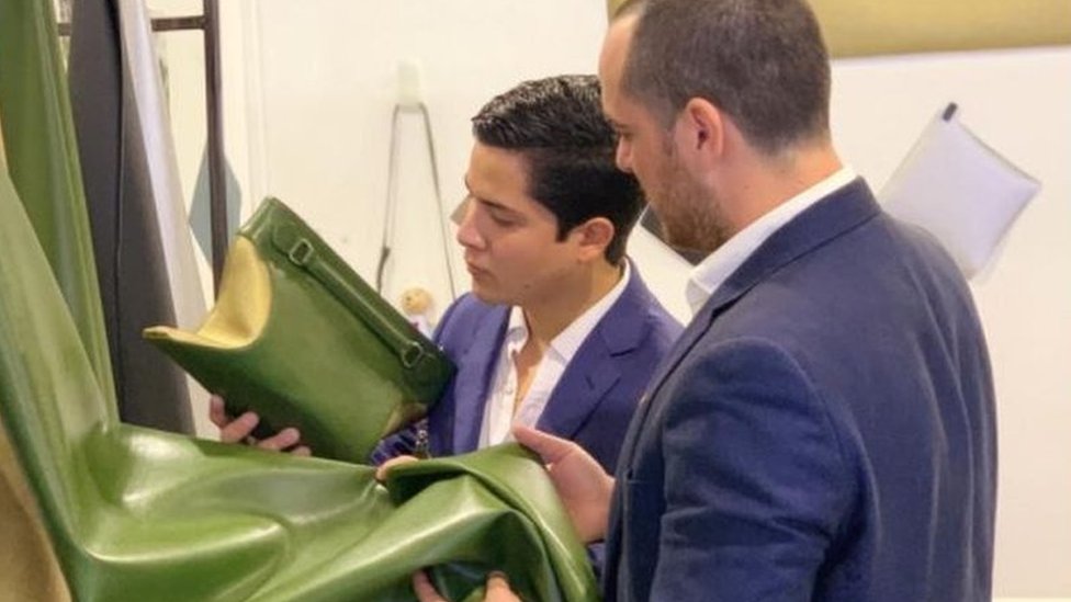 Lopez Velarde and Marte Cazarez looking at a handbag made from their cactus leather