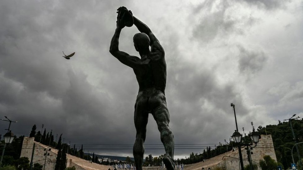 A statue of a discus thrower stands opposite the Athens' Panathenaic stadium or Kalimarmaro, where the first modern Olympic Games began, in Athens