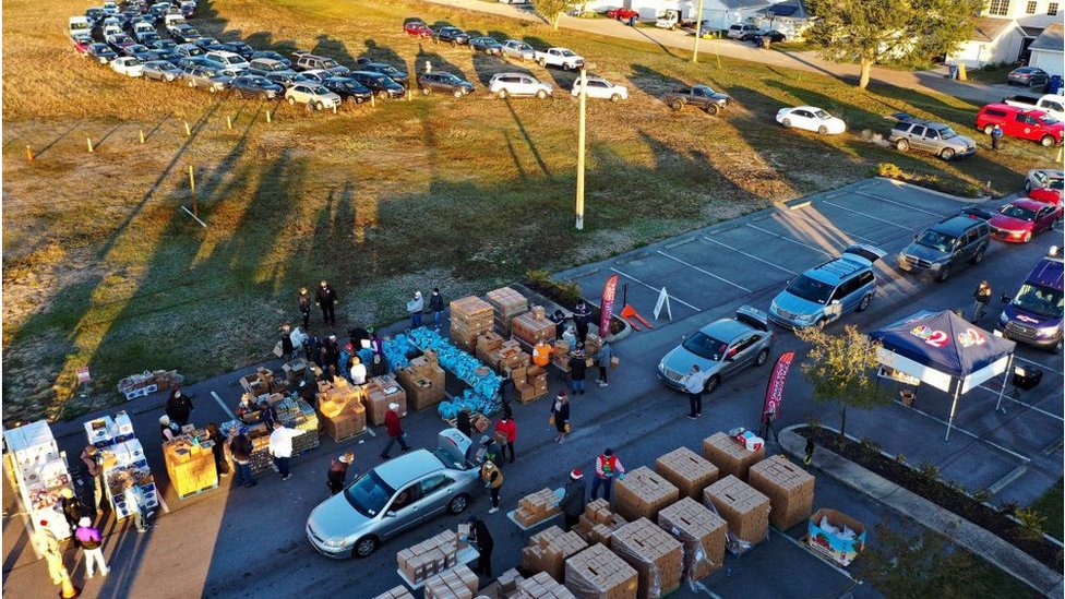 Volunteers load boxes of food assistance into cars at the Share Your Christmas food distribution event sponsored by the Second Harvest Food Bank of Central Florida
