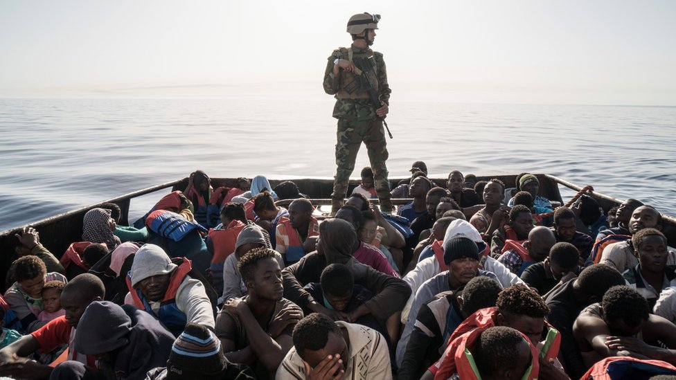 Ливийский пограничник стоит на лодке во время спасения мигрантов - архивный снимок 2017 года