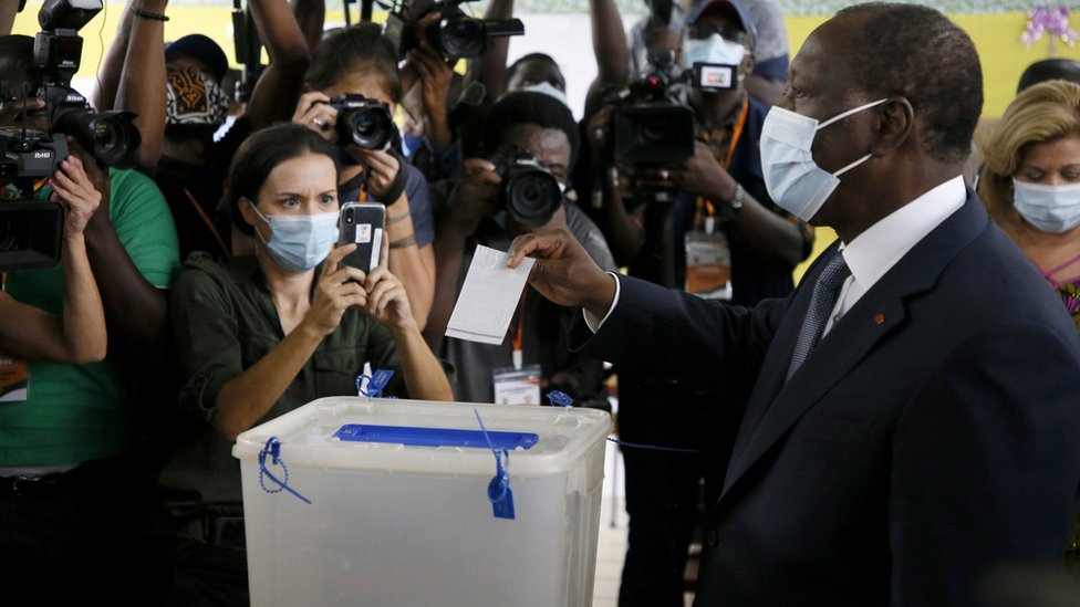 Ivory Coast President Alassane Ouattara (R) casts his vote at a polling station during the first round of the presidential election, in Abidjan, Ivory Coast, 31 October 2020.