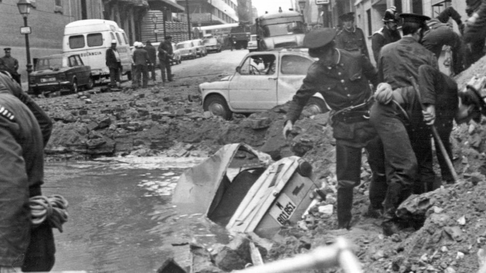 Испанские полицейские ищут среди повреждений, вызванных взрывом бомбы, 20 декабря 1973 г.