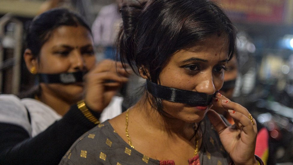 Сторонники Bharatiya Janata Party (BJP) прикрывают рты черной тканью, участвуя в процессии при свечах, призывая к справедливости после недавнего изнасилования и убийства 27-летнего ветеринара