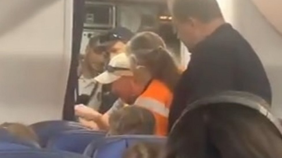 Механик пытается открыть дверь туалета на борту самолета United Airlines