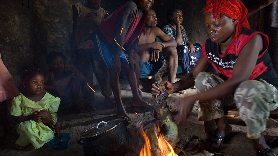 Una mujer sostiene sobre el fuego la carcasa de un mono