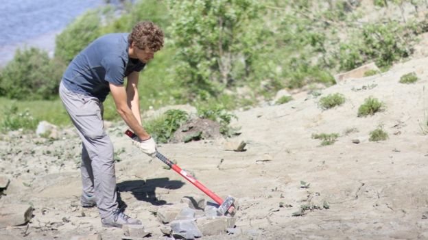 Investigadores examinando rocas en la costa del Mar Balnco en Rusia