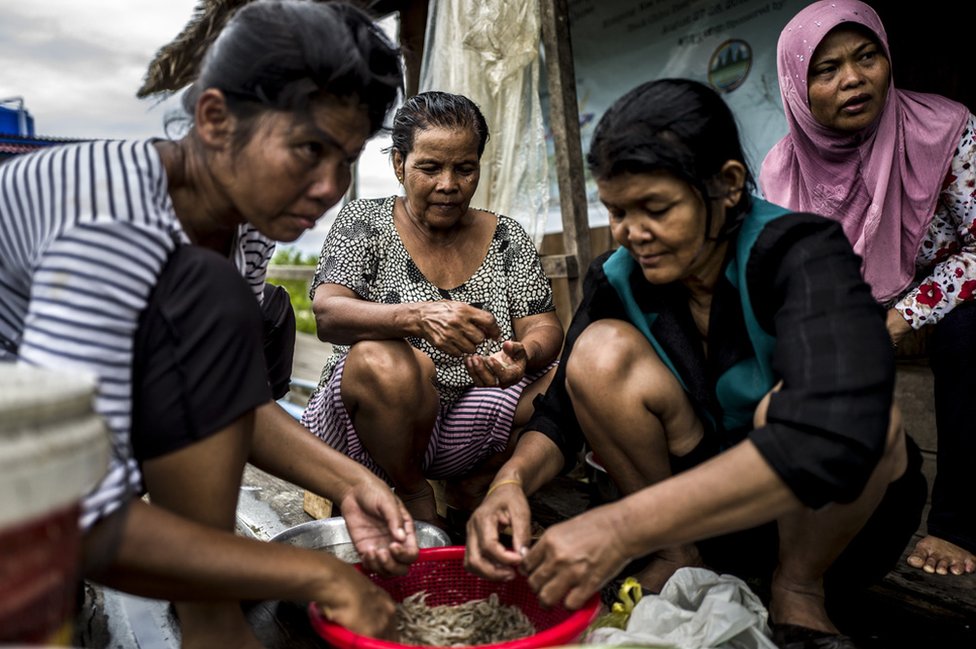 Члены общины Трапанг Сангке готовят рыбу и креветок для ужина